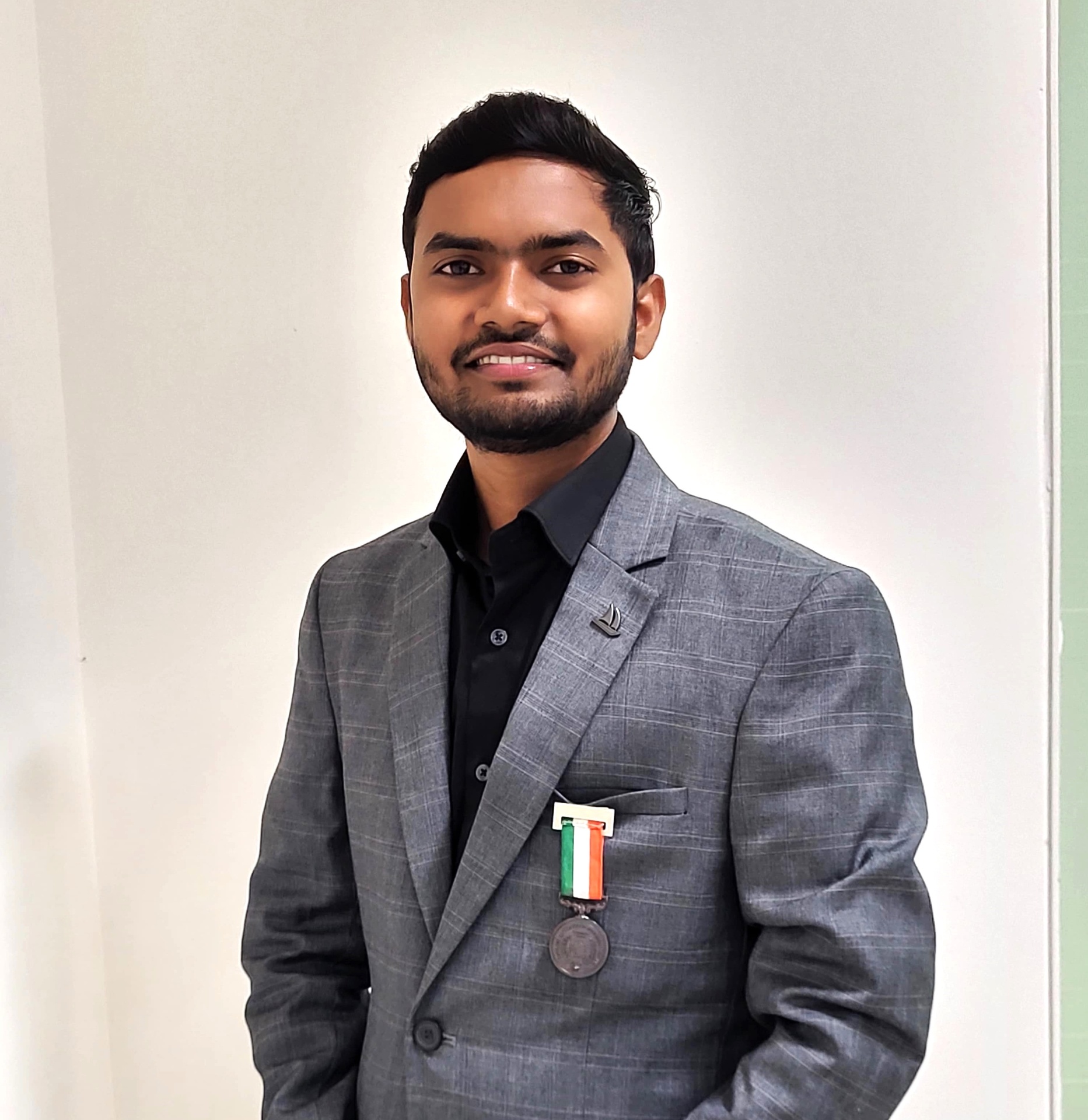 Jainul Abedin, Karamveer Awardee, in a grey check blazer with the Indian tricolour medal